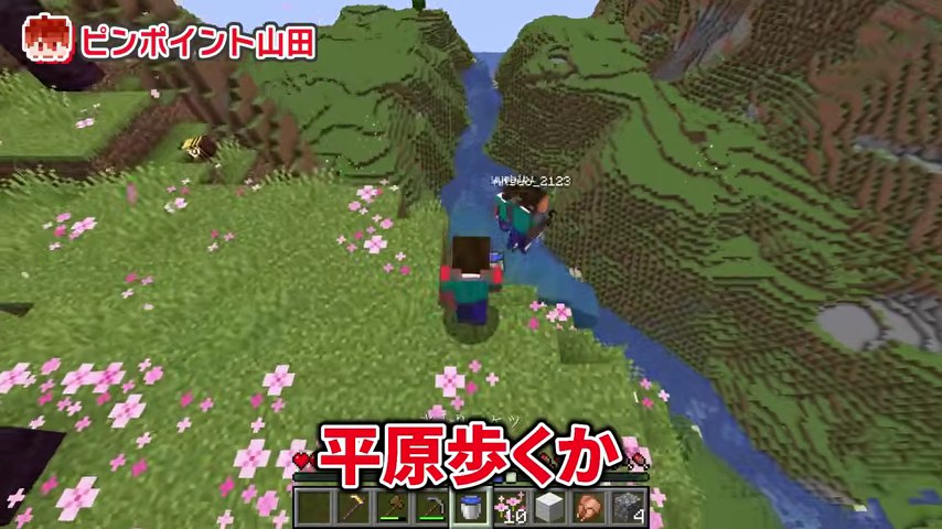桜の木が見える川沿いの崖をマイクラの一行が歩く場面
