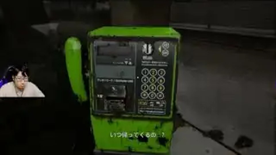 夜の屋外にある緑の公衆電話を正面から調べる『呪われたデジカメ』の画面