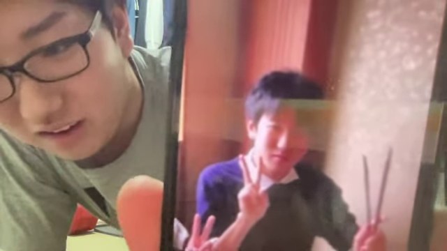 スマホに表示した昔の自分の写真をカメラへ見せるみつお