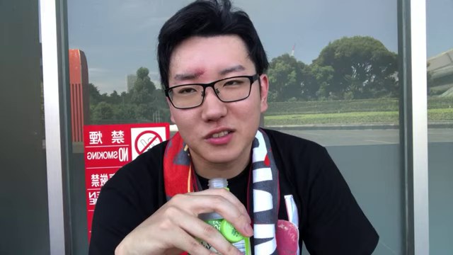 屋外で飲み物を手にブランカ戦を振り返るみつお