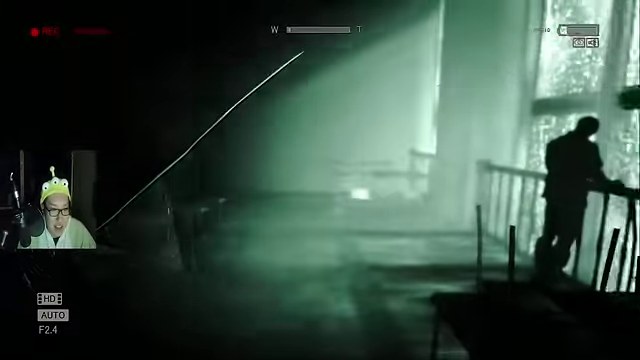 OUTLASTの暗視カメラで映る暗い廊下の奥に人影が立つ画面