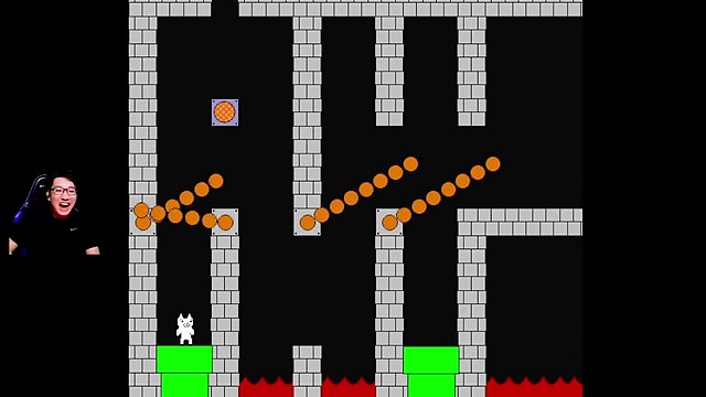 緑の土管の上に白いキャラが立ち、両側でオレンジ色の障害物が回るゲーム画面