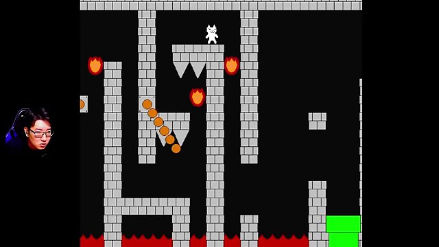 白いキャラが針の上の細いレンガ台に立ち、火玉と右下の緑の土管が見える終盤の場面