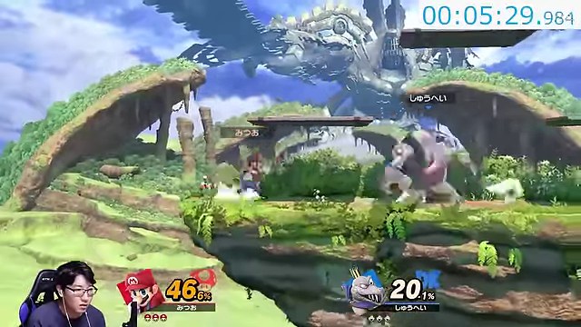 スマブラSPの緑のステージでマリオが大きな相手と対戦し、みつおのカメラ映像が左下にある