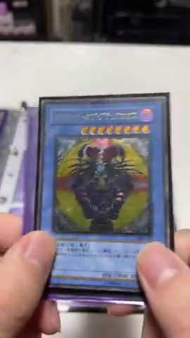 みつおがマジシャン・オブ・ブラックカオスのレリーフカードを手に持って見せる場面